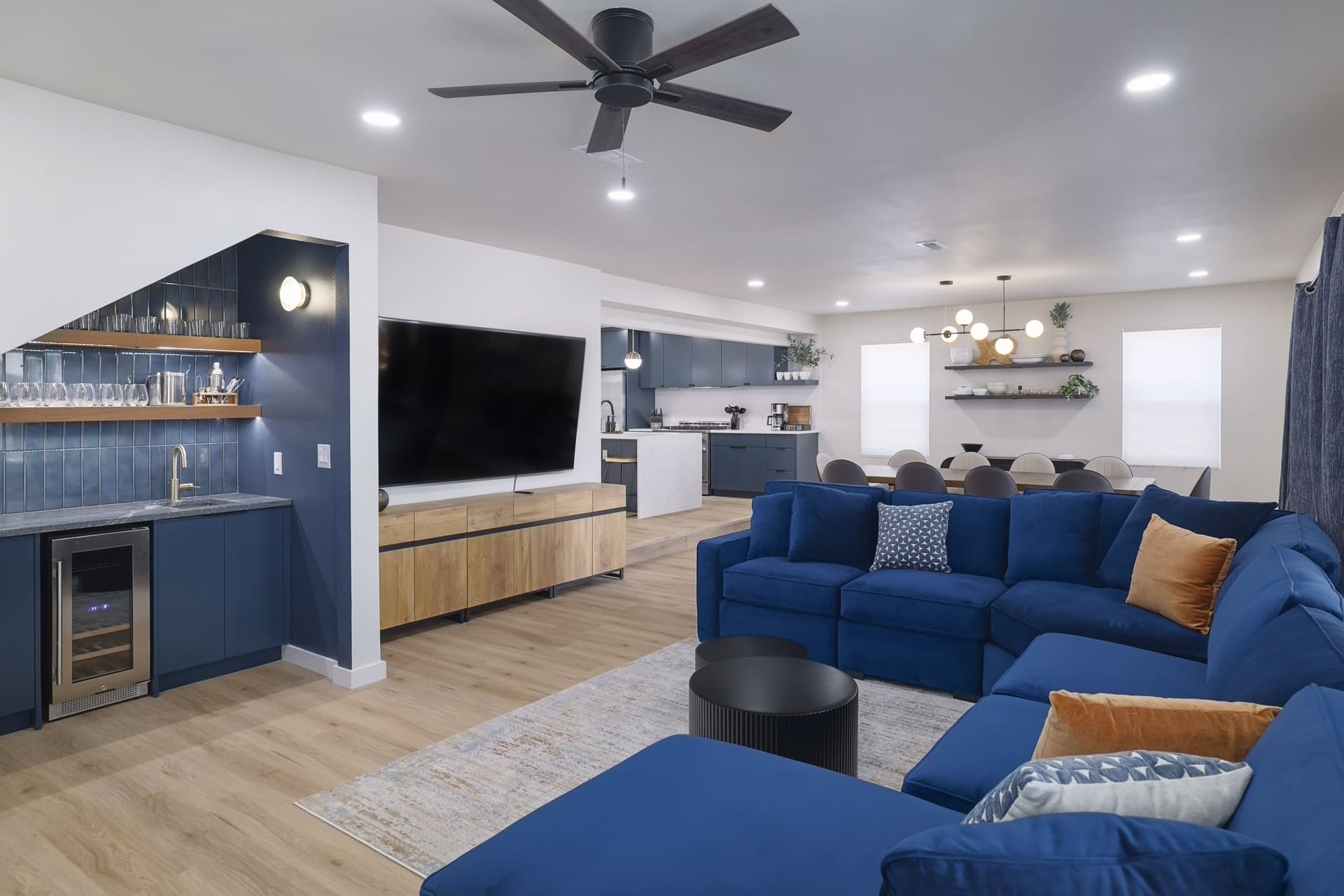 Austin East Bird · Open living room with navy velvet sectional and wet bar