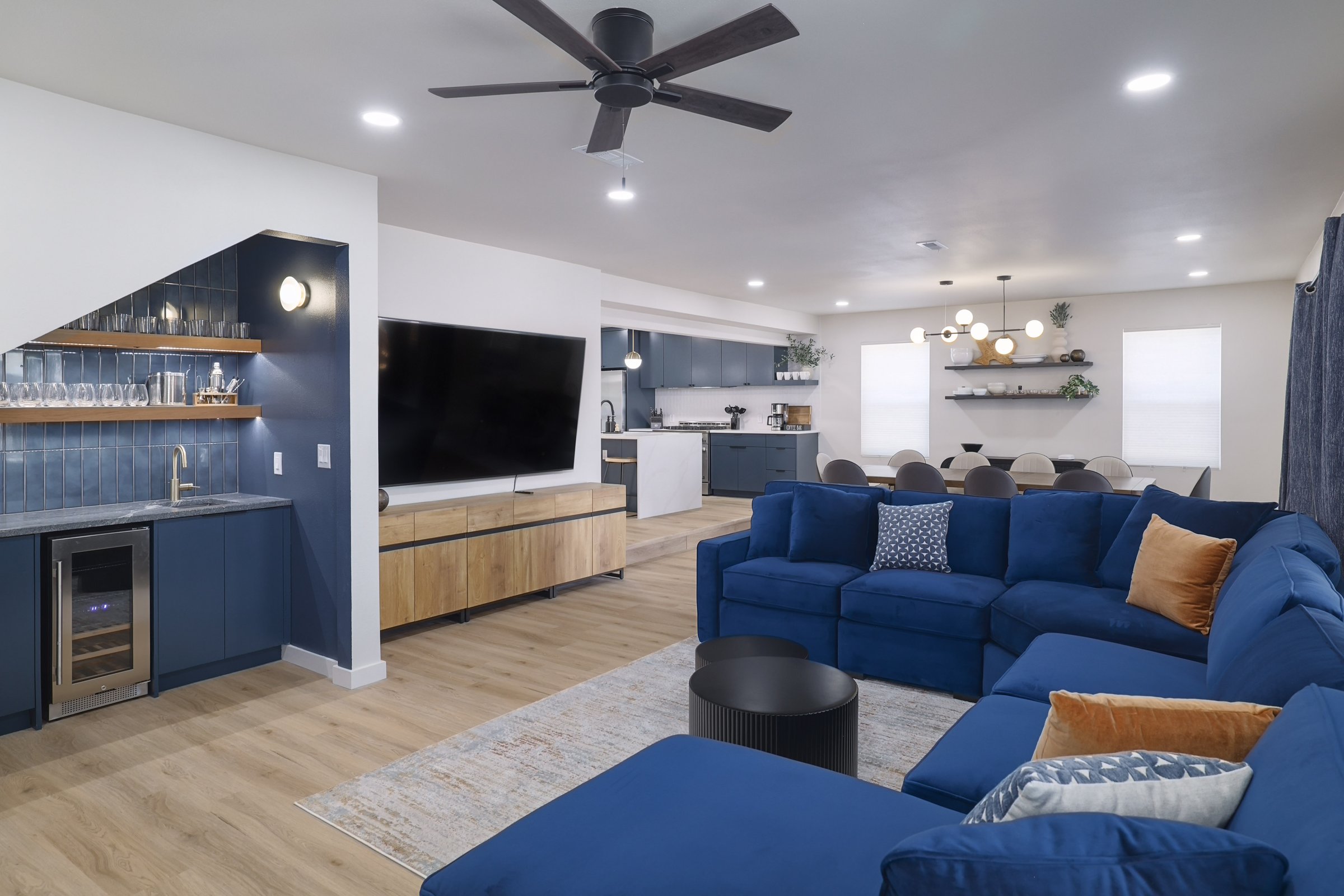 Austin East Bird · Open living room with navy velvet sectional and wet bar