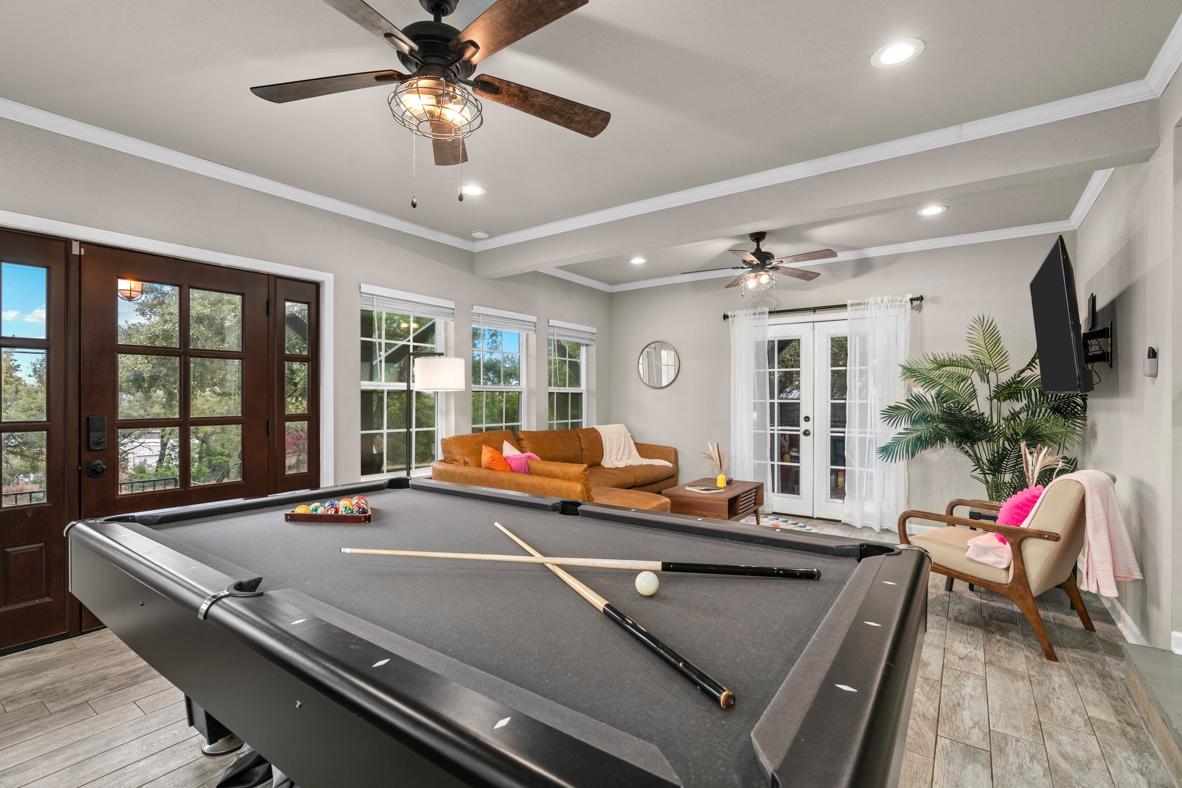 Cosmic Cowboy · Modern open game room with pool table and leather sofa