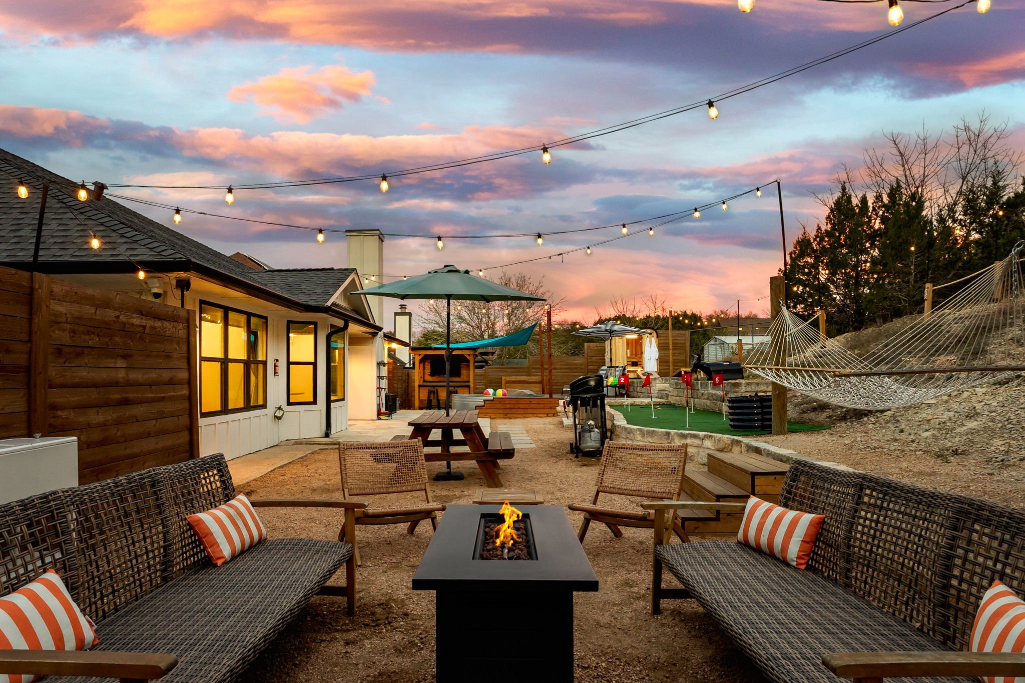 Cowboy Ridge · Outdoor lounge with fire pit, sectional, and hammock at dusk