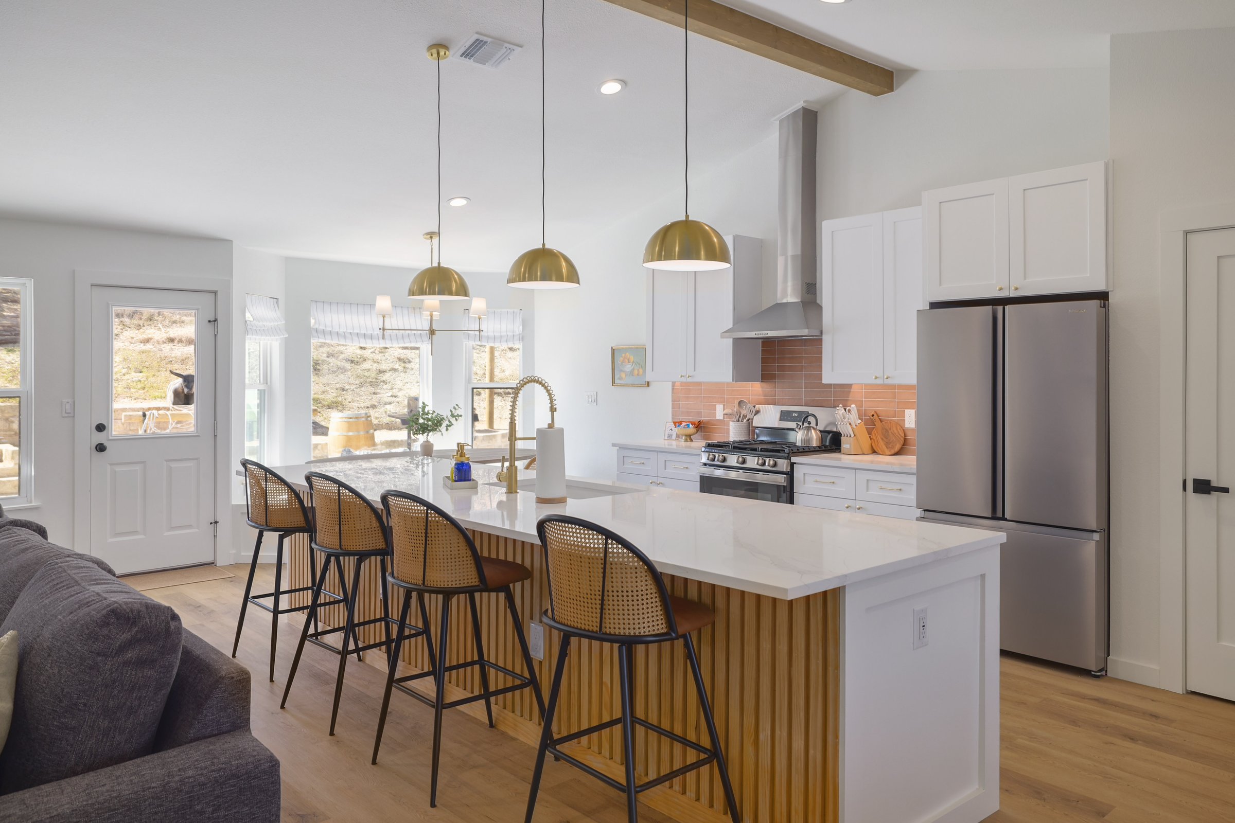Cowboy Ridge · Bright kitchen with white cabinets, quartz island, and brass pendants