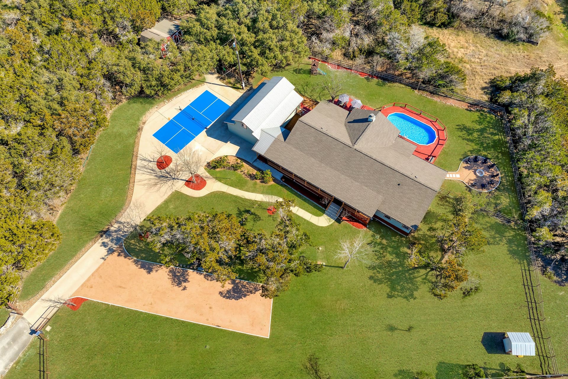 Fitzhugh Lodge · Aerial view with private pool, sport court, and wooded acreage